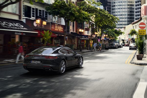 Rear view of a 2020 Porsche Panamara driving down a city street.
